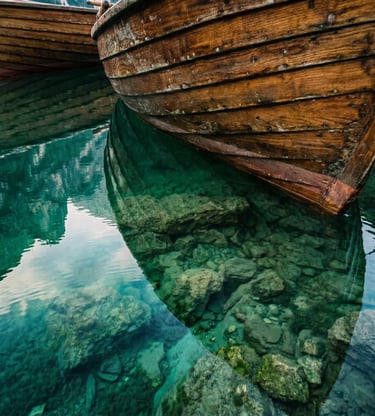Weathered wooden rowboat hull over crystal-clear turquoise water at Lake Braies