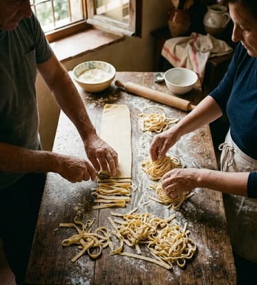 Hands making fresh tagliatelle pasta on flour-dusted farmhouse table during Amalfi cooking class