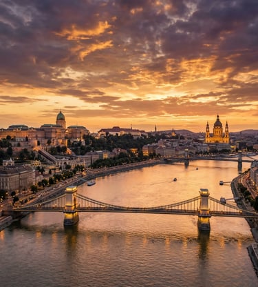 Aerial view of Budapest at sunset with Chain Bridge, Danube River, and Buda Castle glowing orange