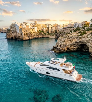 Luxury white yacht Aurora cruising turquoise Adriatic waters below Polignano a Mare cliffs
