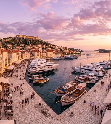 Hvar Town harbor at sunset with luxury yachts and Spanish Fortress on the hill