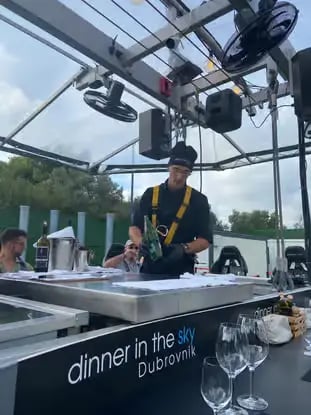 Chef preparing beverages at Dinner in the Sky Dubrovnik platform kitchen with crane above