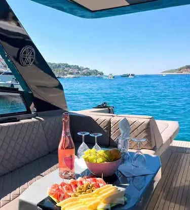 Luxury speedboat deck with rosé wine, fresh fruit and snacks overlooking turquoise Pakleni Islands sea