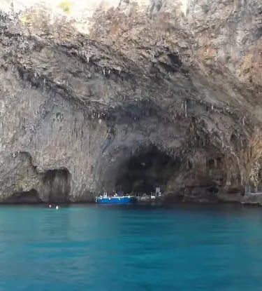 Blue boat anchored at the entrance of Grotta Zinzulusa cave in Castro Puglia