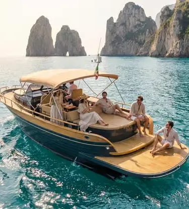 Guests relaxing on a wooden gozzo luxury yacht charter anchored beside the Faraglioni rocks, Capri.