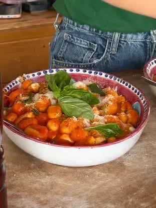 Fresh handmade gnocchi in tomato sauce with basil served in traditional ceramic bowl