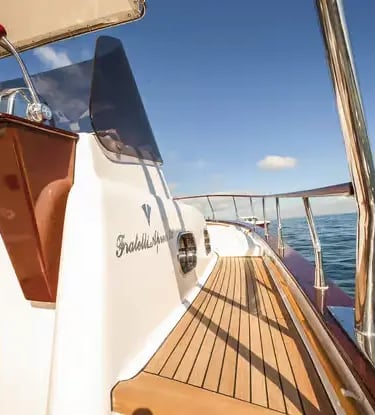 Wooden steering wheel and teak deck of a traditional Gozzo boat on the Amalfi Coast