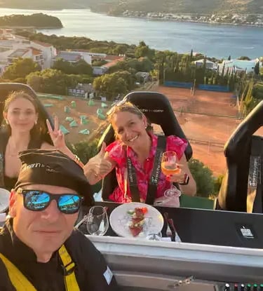 Three guests selfie on elevated Dinner in the Sky Dubrovnik platform above Adriatic Sea