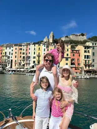 Family enjoying a private boat tour in Portovenere with colorful village backdrop