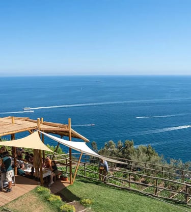 Outdoor dining terrace at Luna d'Agerola overlooking Gulf of Salerno with boats below