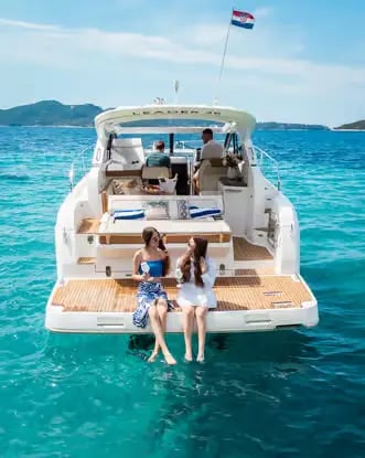 Two women relaxing on a private yacht swim platform in the Adriatic