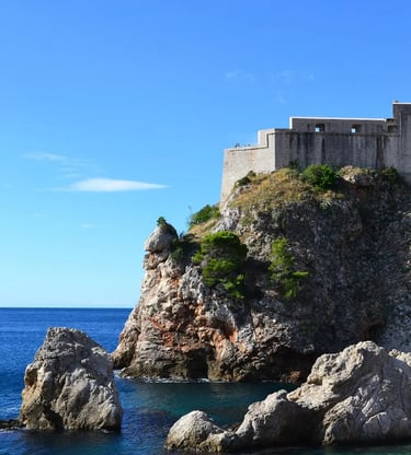 Fort Lovrijenac rising above rocky Adriatic coastline under clear blue sky Dubrovnik