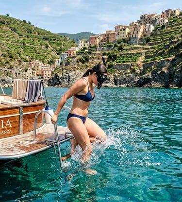 Woman with snorkeling gear entering turquoise water from a private boat near Cinque Terre terraces