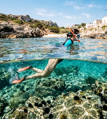 Woman snorkeling in crystal-clear water above rocky seabed, Puglia coastline