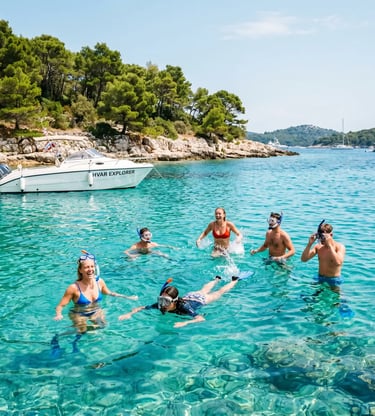 Group snorkeling in turquoise water near Hvar Explorer boat at Pakleni Islands, Croatia