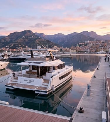 Luxury power catamaran docked at Marina d'Arechi Salerno with mountains at dawn