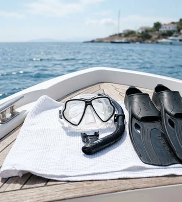 Snorkeling mask, snorkel, and fins on a white towel on a private boat deck near the coast