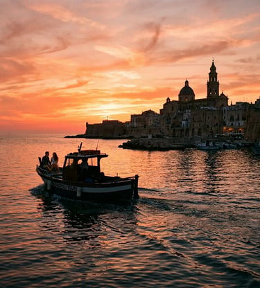 Couple on Monopoli Tours boat sailing toward old town cathedral during vivid orange Puglia sunset