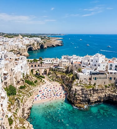 Aerial view of Polignano a Mare whitewashed cliffs and Lama Monachile beach with turquoise water