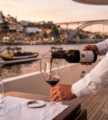Sommelier pouring Quinta do Vale Meão red wine on a luxury yacht in Porto
