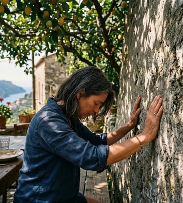 Traveler pressing hands against ancient stone wall at Luna d'Agerola farmhouse under lemon trees