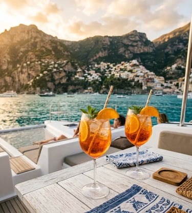 Two aperol spritz cocktails on luxury catamaran deck with Amalfi Coast sunset view