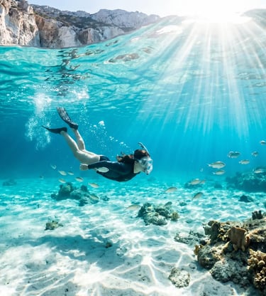 Snorkeler exploring crystal-clear turquoise water during Milos catamaran cruise to Polyegos