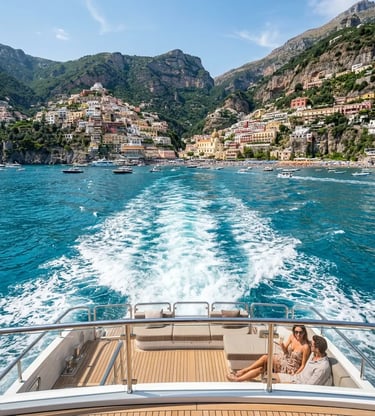  Couple on luxury yacht stern with Positano cliffside village and wake trail behind