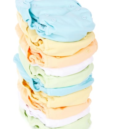 Newborn diapering essentials including diapers, wipes, rash cream, and changing mat.