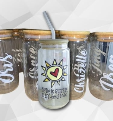 Soda glass and bamboo lid and a glass straw with a uv transfer sticker stick to it