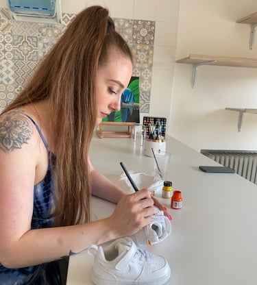 Ragazza di profilo che realizza custom fatte a mano su scarpe Nike bianche