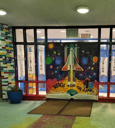 Exterior school doors with a space shuttle and the name of the school painted on it.