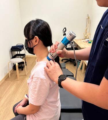Shockwave therapy on upper back at Sinisana Chiropractic clinic.