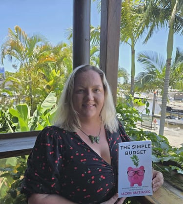 Jackie Matjasec, founder of The Simple Budget, holding a copy of The Simple Budget book.