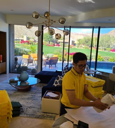 Professional packer in a big win moving carefully wraps items in a luxury home with desert views.