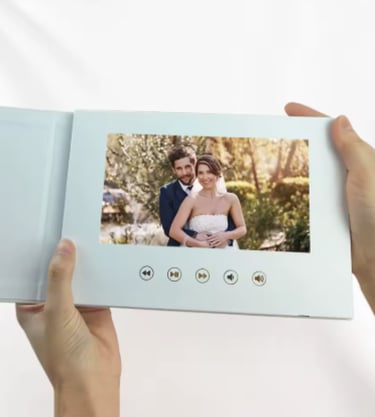 Hands holding a white digital video wedding album playing a romantic couple's ceremony movie.