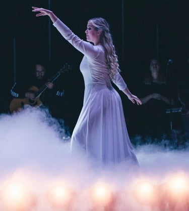 a woman in a white dress is dancing on stage at church