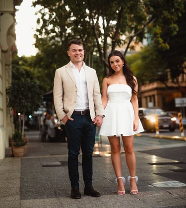 a man and woman holding hands and walking down the street