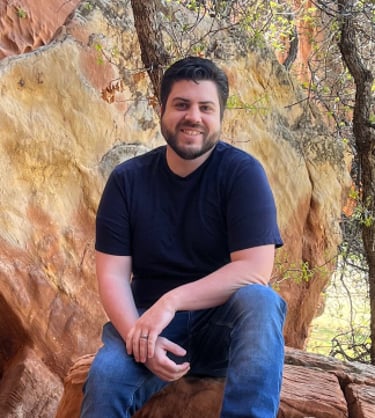 Christopher Carpenter sitting on a rock formation in the Utah mountains.