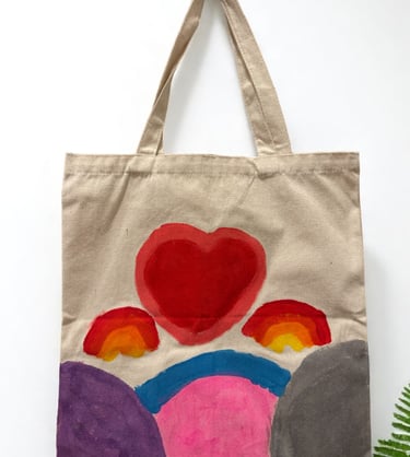 a tote bag with a heart shaped painting on it