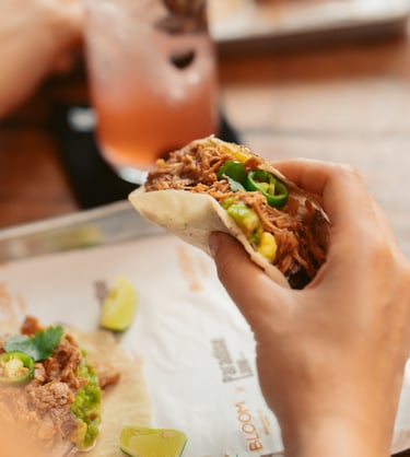 a person holding a sandwich sandwich on a plate