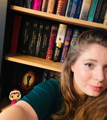 Mandy, créatrice de Révéria, devant sa bibliothèque remplie de romans