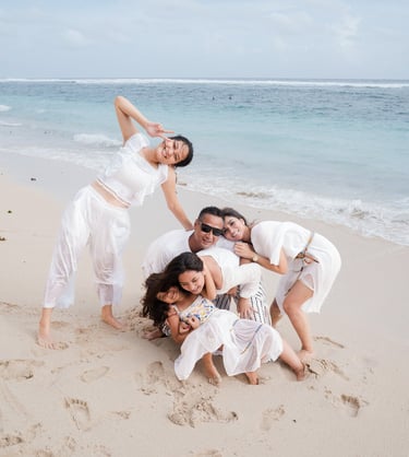 Family laughing together on the sand during a beach session at Karma Kandara Bali  