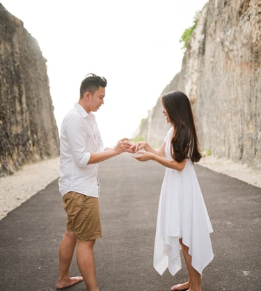 Proposal moment on a cliff road at Melasti Beach Bali with couple standing together
