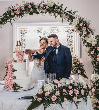 sposi al taglio della torta con addobbi floreali
