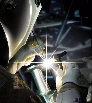 a person welding a piece of metal with a light shining on the side
