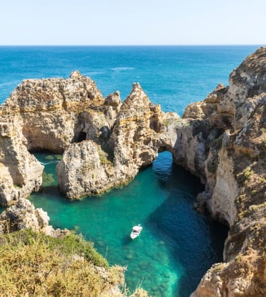 a boat in the water near a cliff