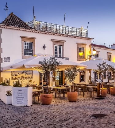 a street scene with a couple of tables and umbrellas