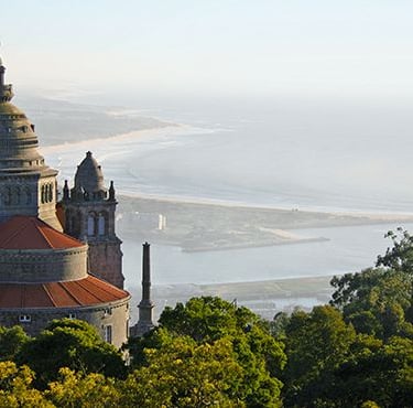 a large building with a tower with a clock tower in the background