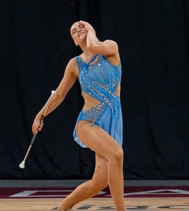 a woman in a blue dress during a twirling competition